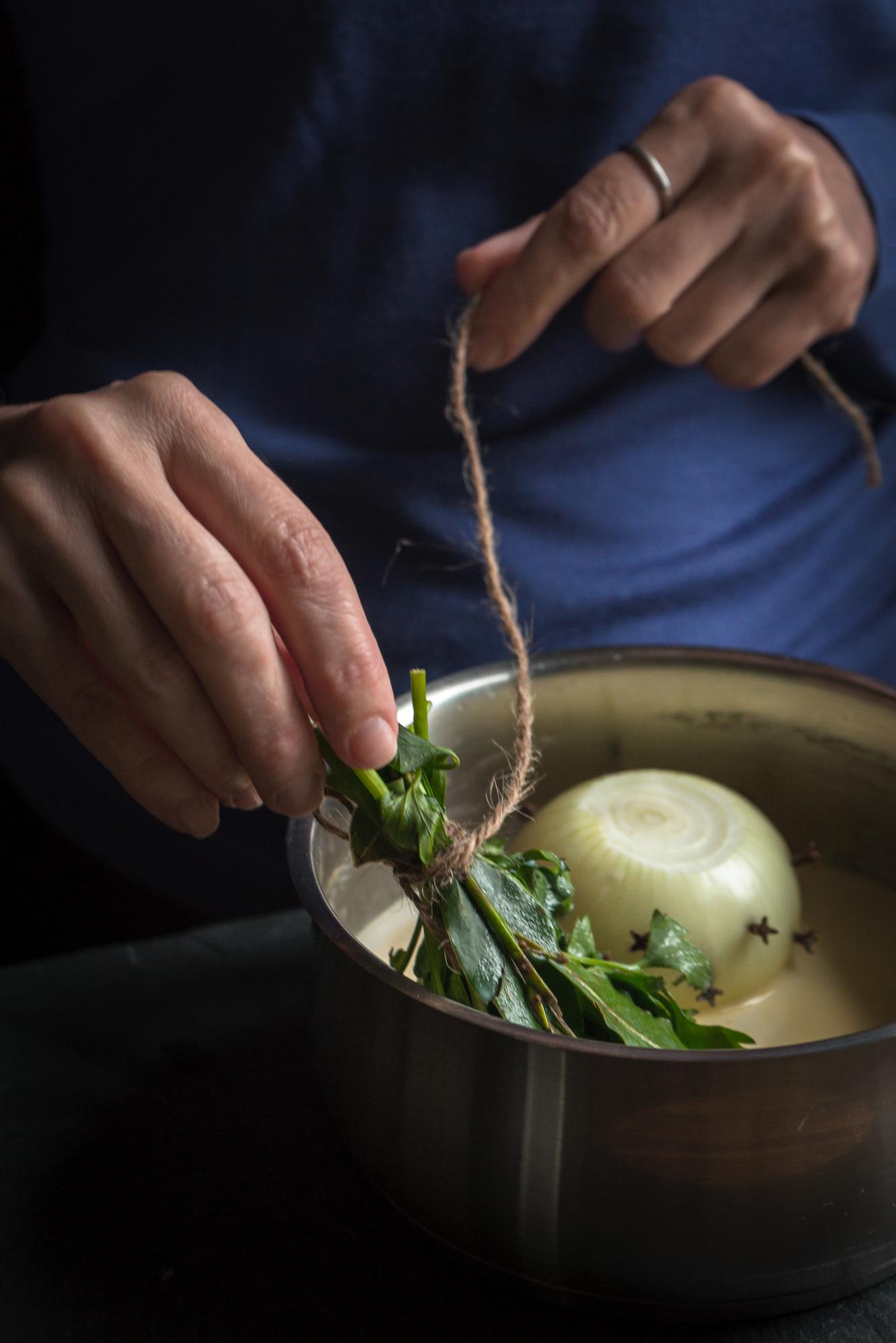 Close-up of hands plating a dish